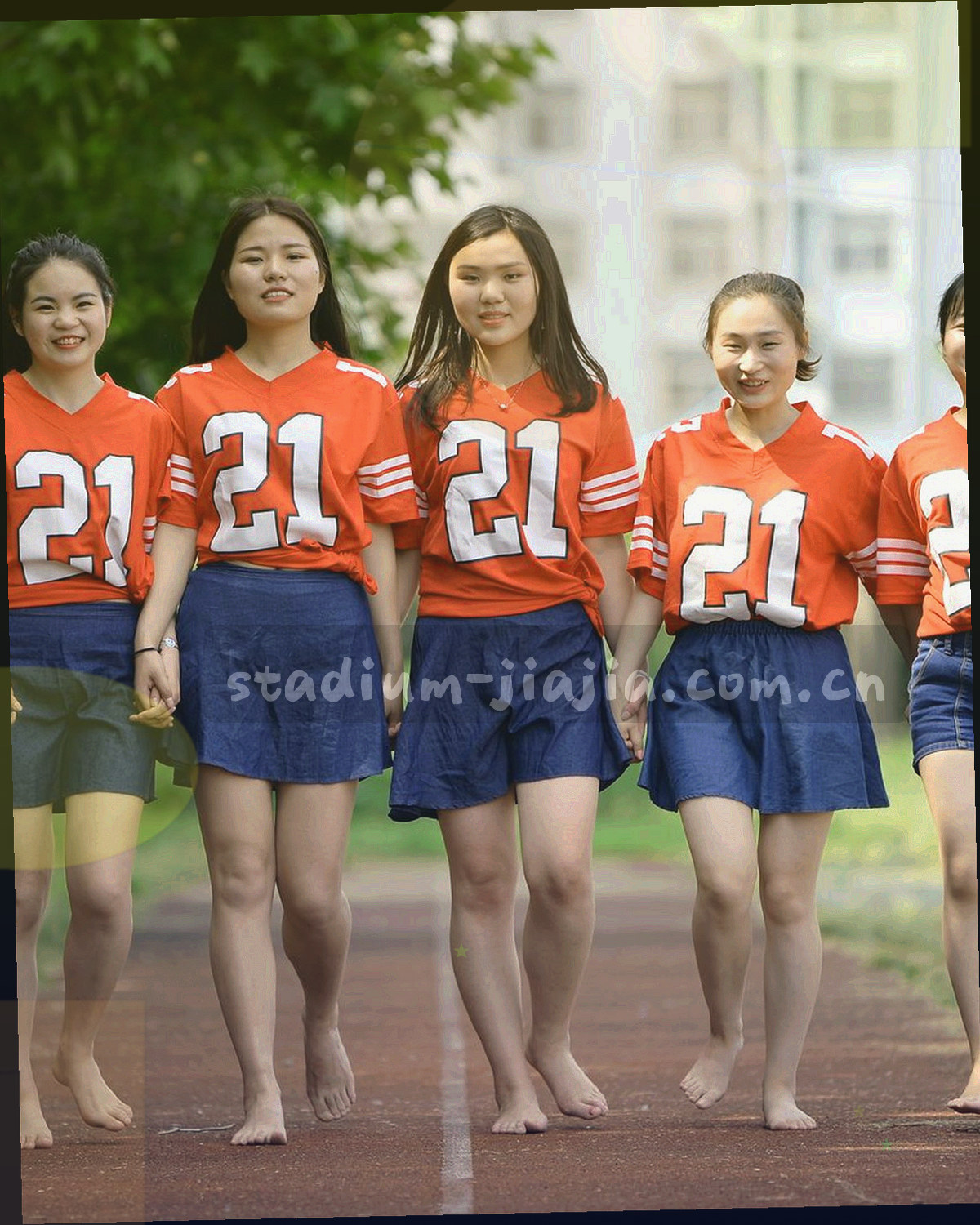 球场俯拍，草皮纹理与看台边界形成纵向层次，画面干净无人像